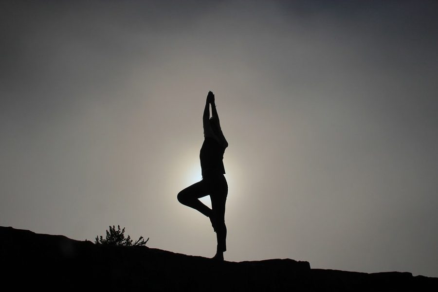 Silhouette of a person in a yoga pose at sunrise